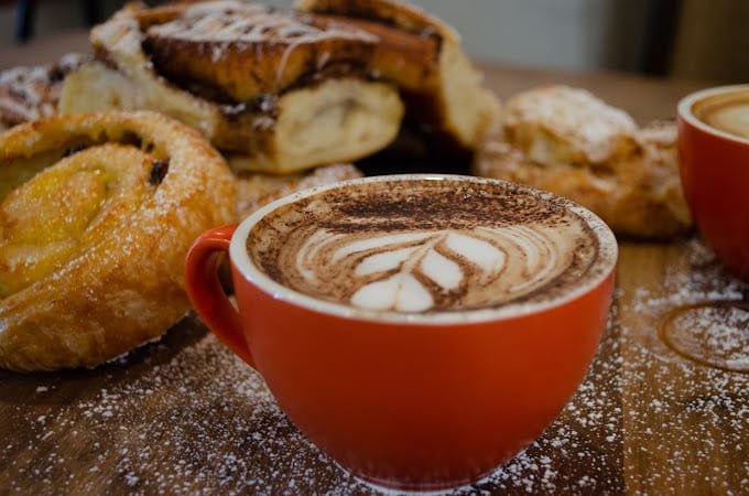 Coffee with Cinnamon Rolls on a wooden table with sugar on it