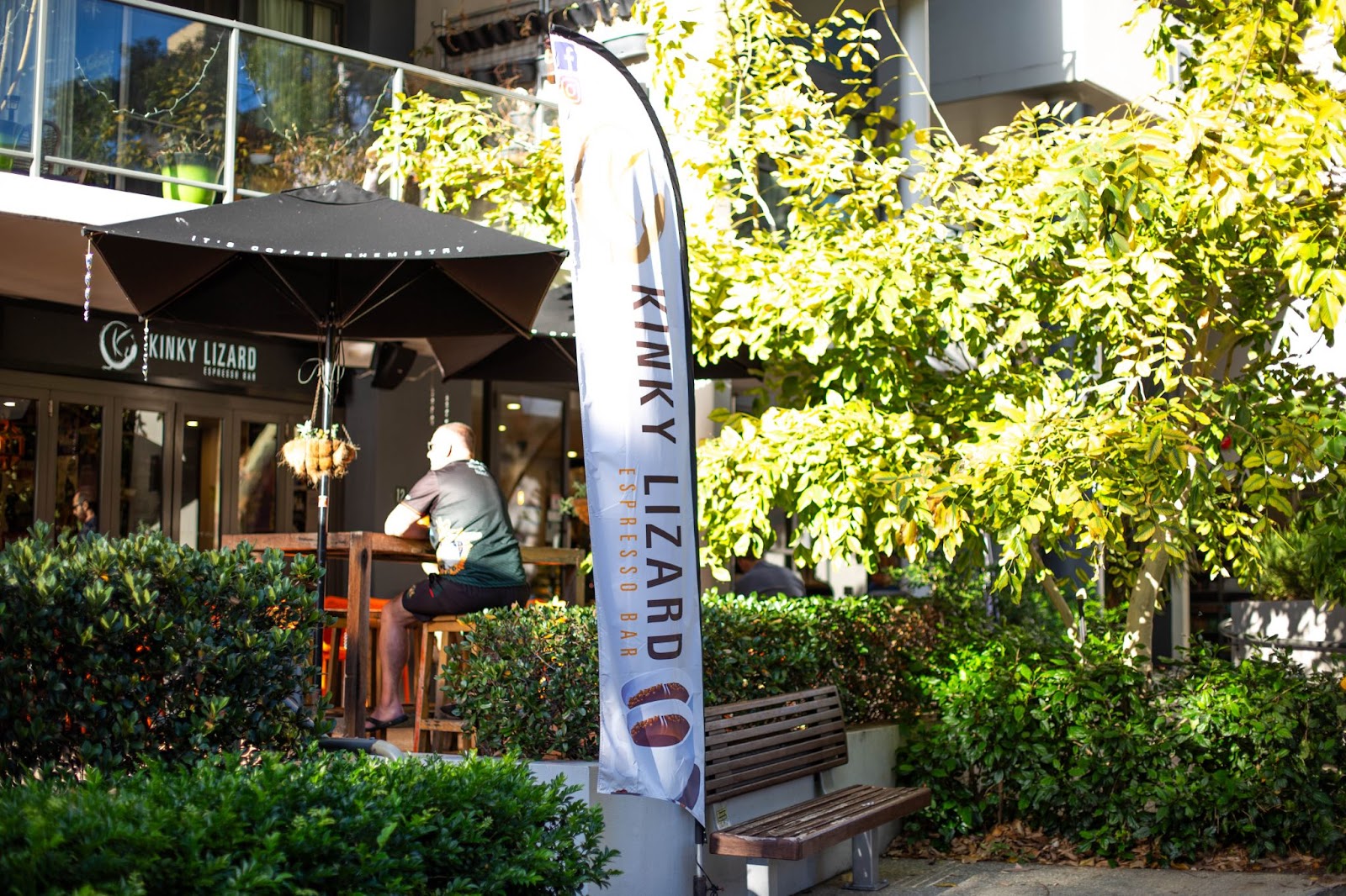 An outdoor restaurant table next to a garden on a sunny day in Perth.